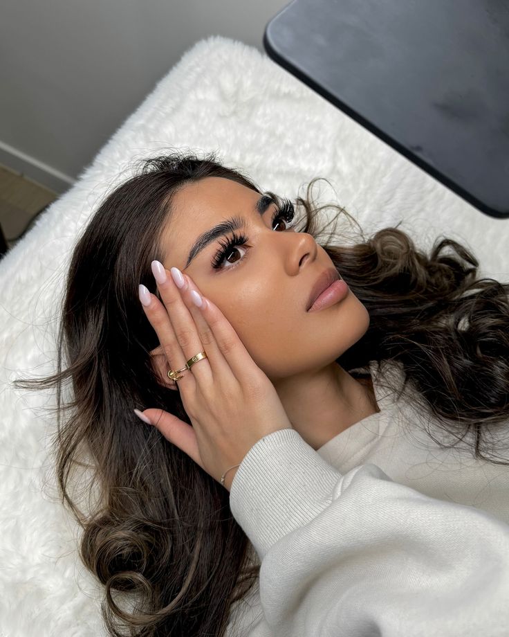 Client with volume lash extensions and glossy nude nails
